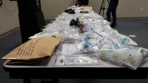 The sweep evidence took several tables in order to display. Drugs, money and guns were all involved with the sweep. Photo by Carrie Gloeckner.
